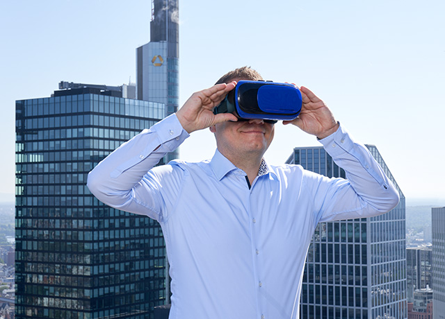 Mann mit virtual reality Brille vor Frankfurter Skyline